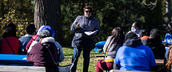 a woman talking to a group of people outside